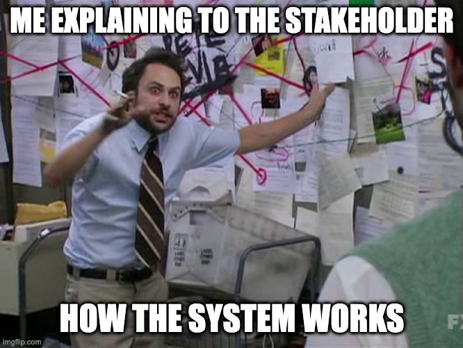 conspiracy-guy meme. Man excitedly explaining a complex system using a wall covered with diagrams and notes, representing a humorous office scenario. Caption: Me explaining to the stakeholder how the system works.