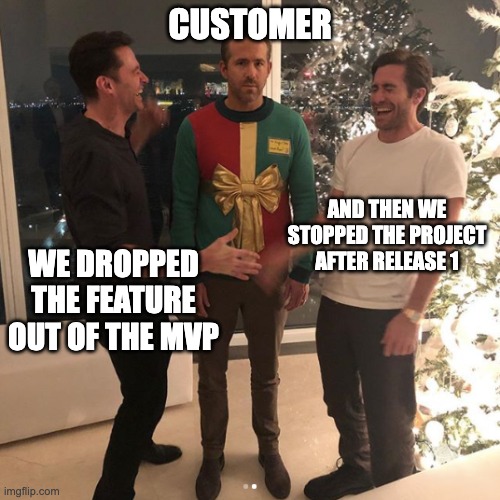 Meme: Ryan Reynold between Hugh Jackman and Jake Gyllenhaal. Ryan is humorously dressed as a gift and looking annoyed while Hugh and Jake are laughing out loud. Caption for Ryan is "Customer", for Hugh "We dropped the feature out of the MVP" and for Jake "And then we stoped the project after release 1.